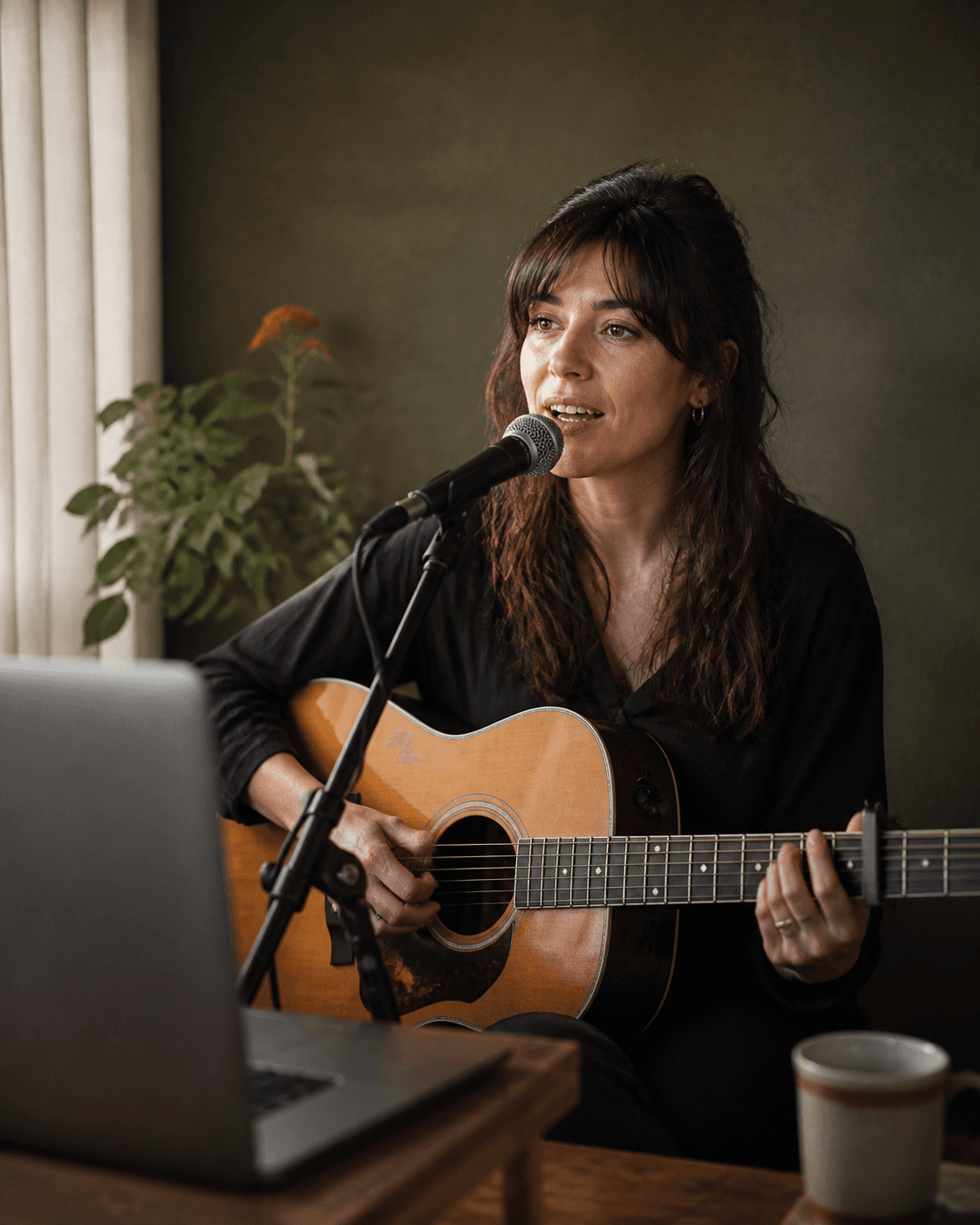 Zangeres met gitaar tijdens een live optreden vanuit haar studio